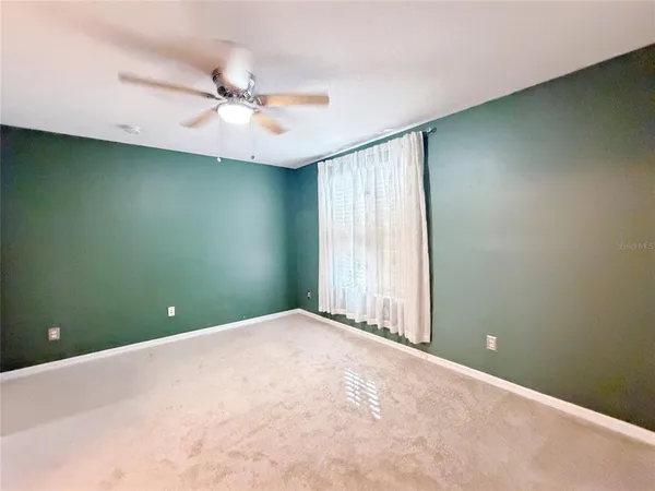 a view of a room with a ceiling fan and a window