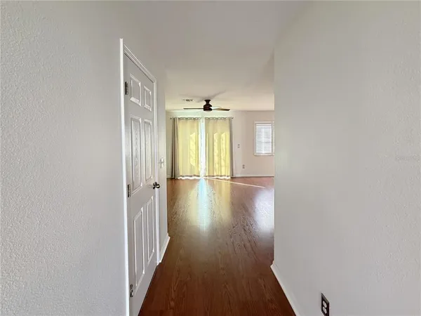 a view of a hallway with wooden floor and closet