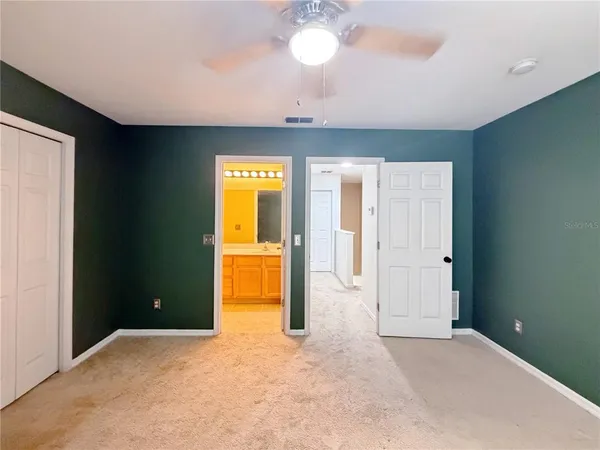 a view of an empty room with a bathroom and a window