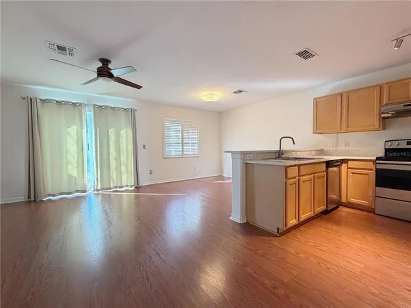 a view of a kitchen with a sink and wooden floor
