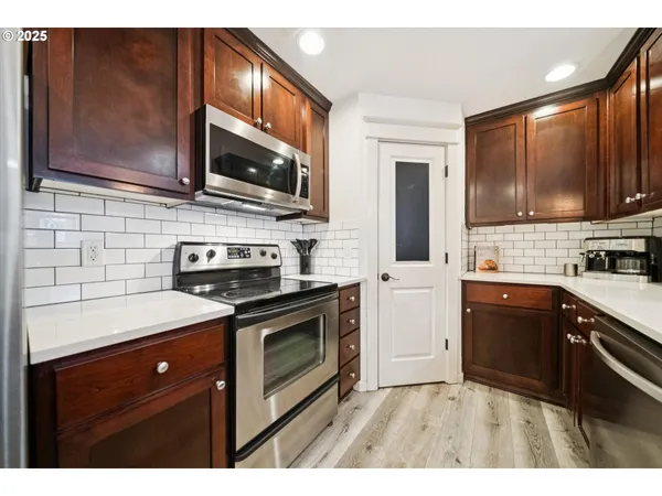 a kitchen with stainless steel appliances a stove microwave and sink