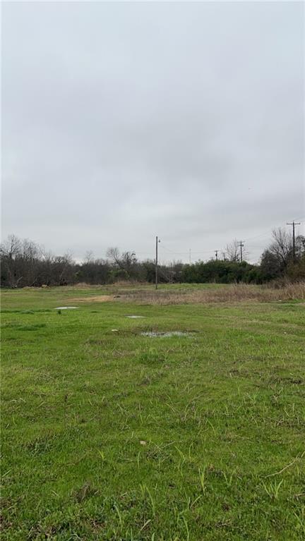 a view of yard with ocean and trees in the background