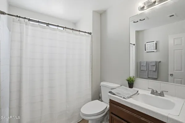 a bathroom with a sink vanity mirror and toilet