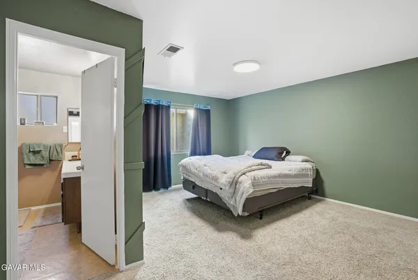 a bedroom with a bed and a mirror