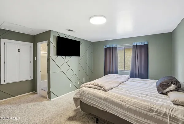 a bedroom with a bed and a flat screen tv