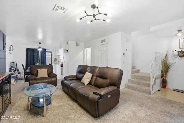 a living room with furniture and a chandelier