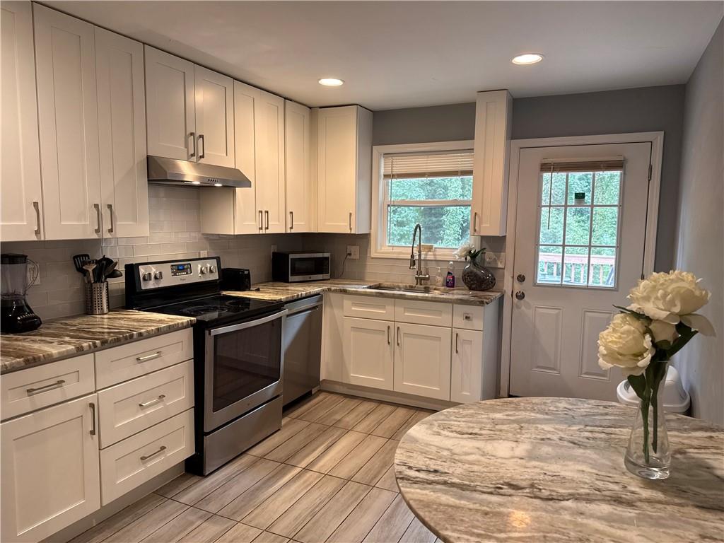 1485 Janmar Drive Decatur, GA 30032 - Photo 21 of 34 a kitchen with granite countertop a stove sink and cabinets