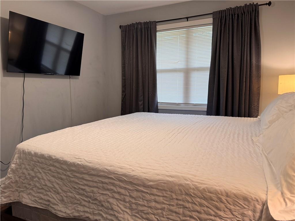 1485 Janmar Drive Decatur, GA 30032 - Photo 23 of 34 a large bed with a flat tv screen and a window