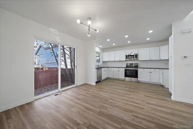 a kitchen with granite countertop white cabinets and white appliances
