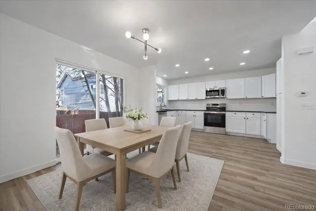 a kitchen with granite countertop white cabinets and white appliances