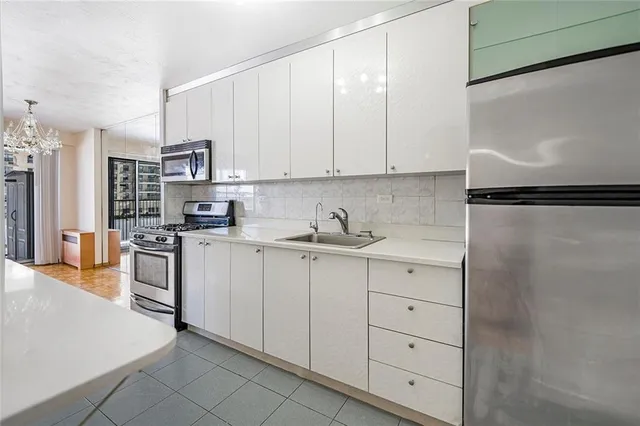 a kitchen with white cabinets and white appliances