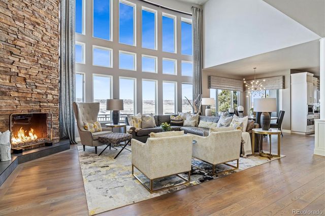 a living room with furniture a fireplace and a floor to ceiling window