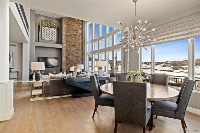 a dining room with furniture a chandelier and wooden floor