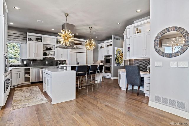 a large white kitchen with lots of counter space a sink and appliances