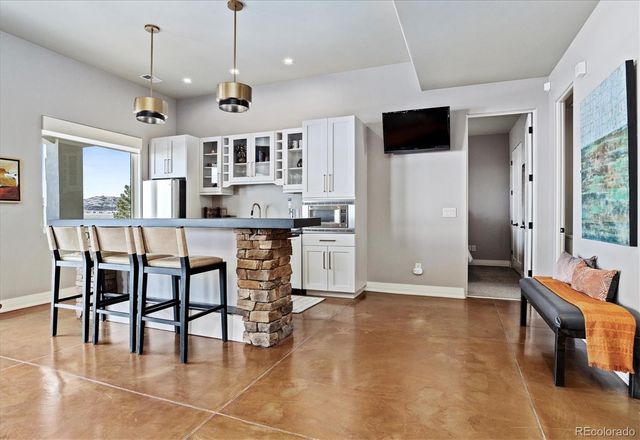 a open kitchen with stainless steel appliances granite countertop a stove top oven a sink a dining table and chairs