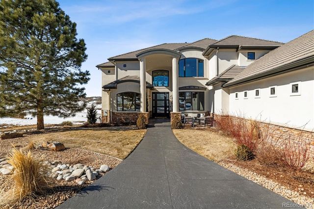a view of a white house with large windows and a small yard