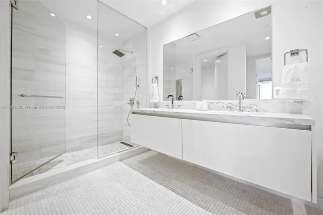 a bathroom with a sink double vanity granite tub and a mirror