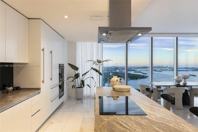a living room with furniture kitchen view and a large window