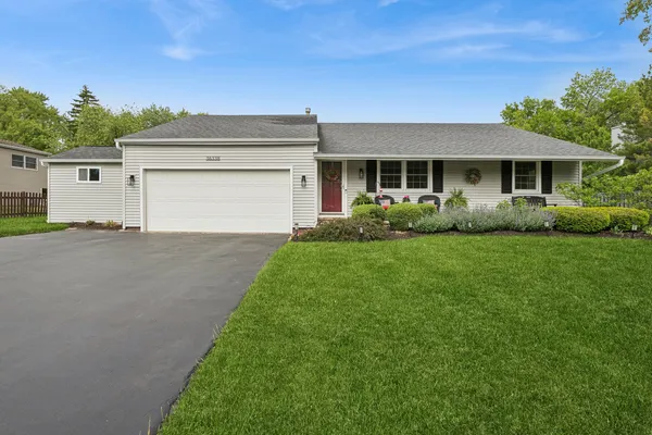a front view of a house with a garden and plants