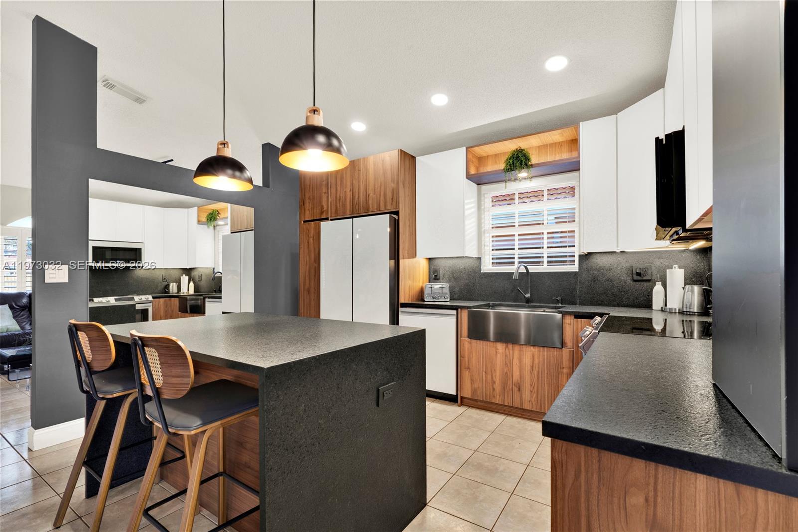 16269 Southwest 78th Terrace Miami, FL 33193 - Photo 14 of 45 a kitchen with stainless steel appliances granite countertop a stove top oven a sink a dining table and chairs with wooden floor