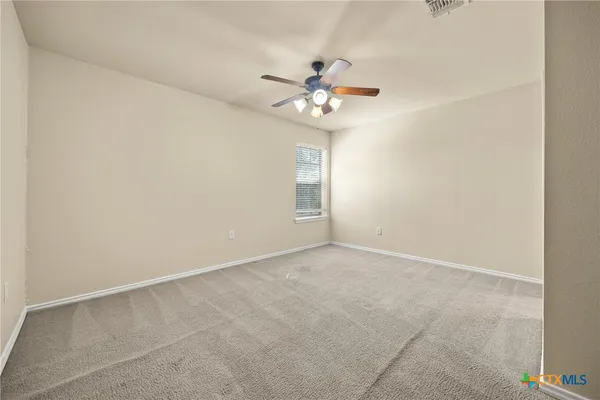 an empty room with a window and a fan