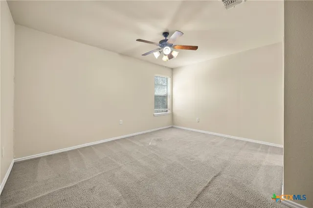 an empty room with a window and a fan