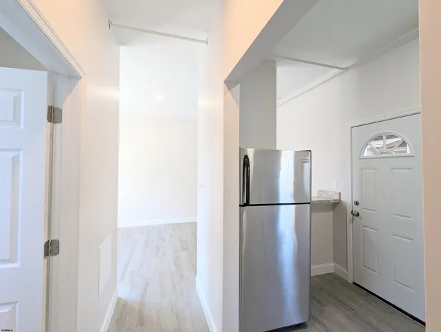 a kitchen with a white cabinets and wooden floor