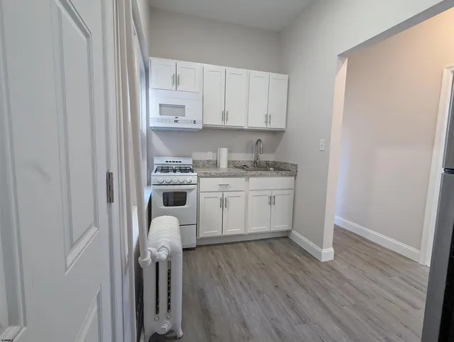 a kitchen with white cabinets and white appliances
