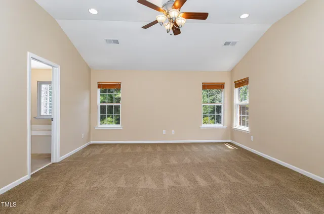 an empty room with windows and fan