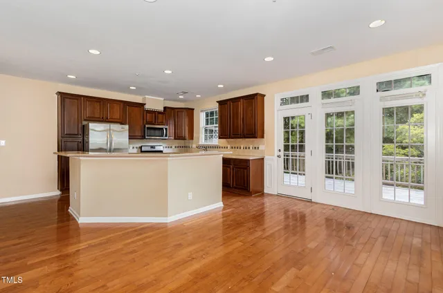 a kitchen with stainless steel appliances granite countertop a refrigerator stove top oven and sink