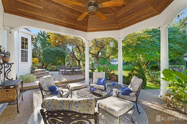 a view of a patio with couches chairs potted plants and palm trees