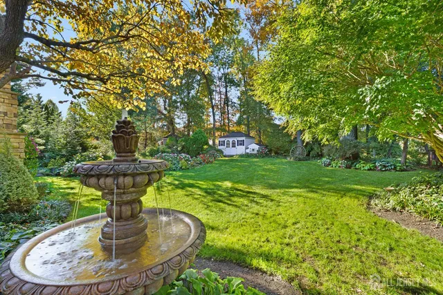 a view of a fountain in the garden with potted plants