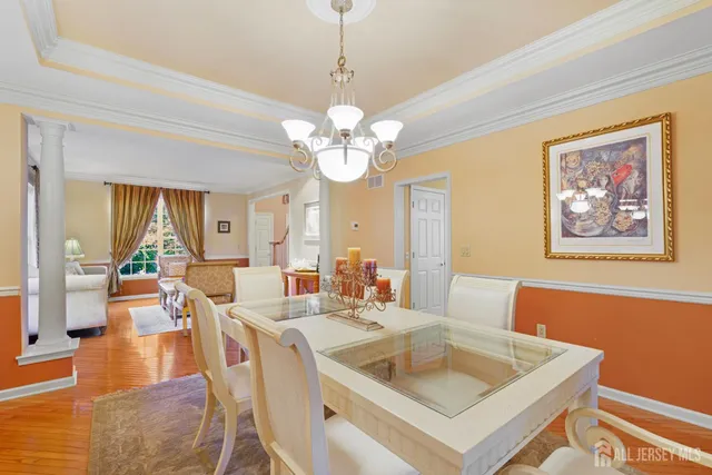 a view of a dining room with furniture a chandelier and wooden floor