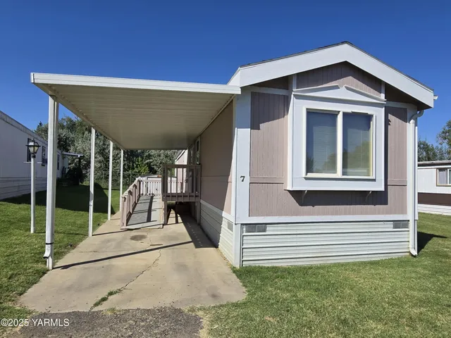 a view of a house with a small yard and wooden fence