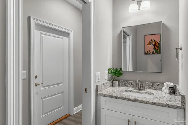 a bathroom with a granite countertop sink and a mirror