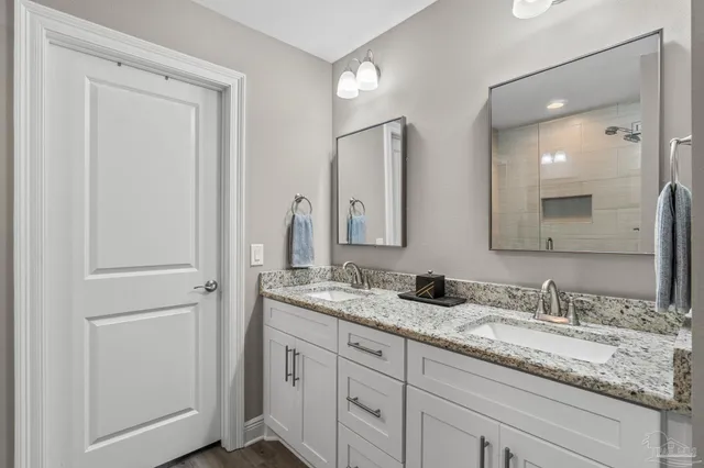 a bathroom with double sink and a mirror