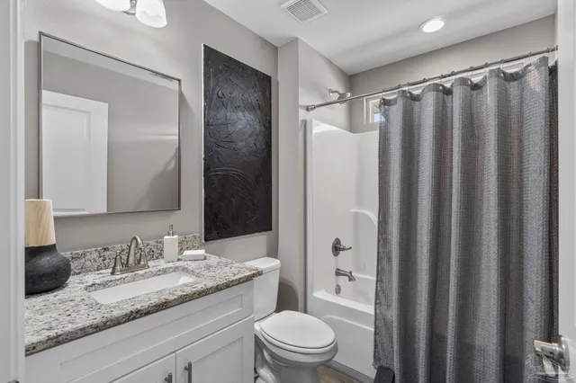 a bathroom with a granite countertop sink toilet and shower