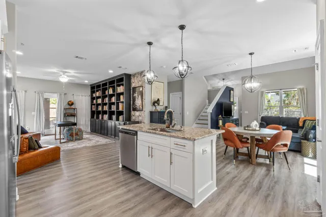 a view of a kitchen and living room with wooden floor