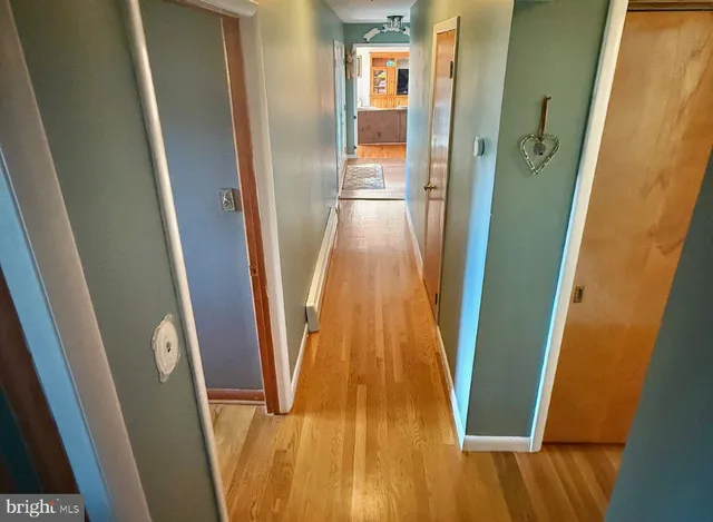 a view of a hallway with wooden floor and stairs