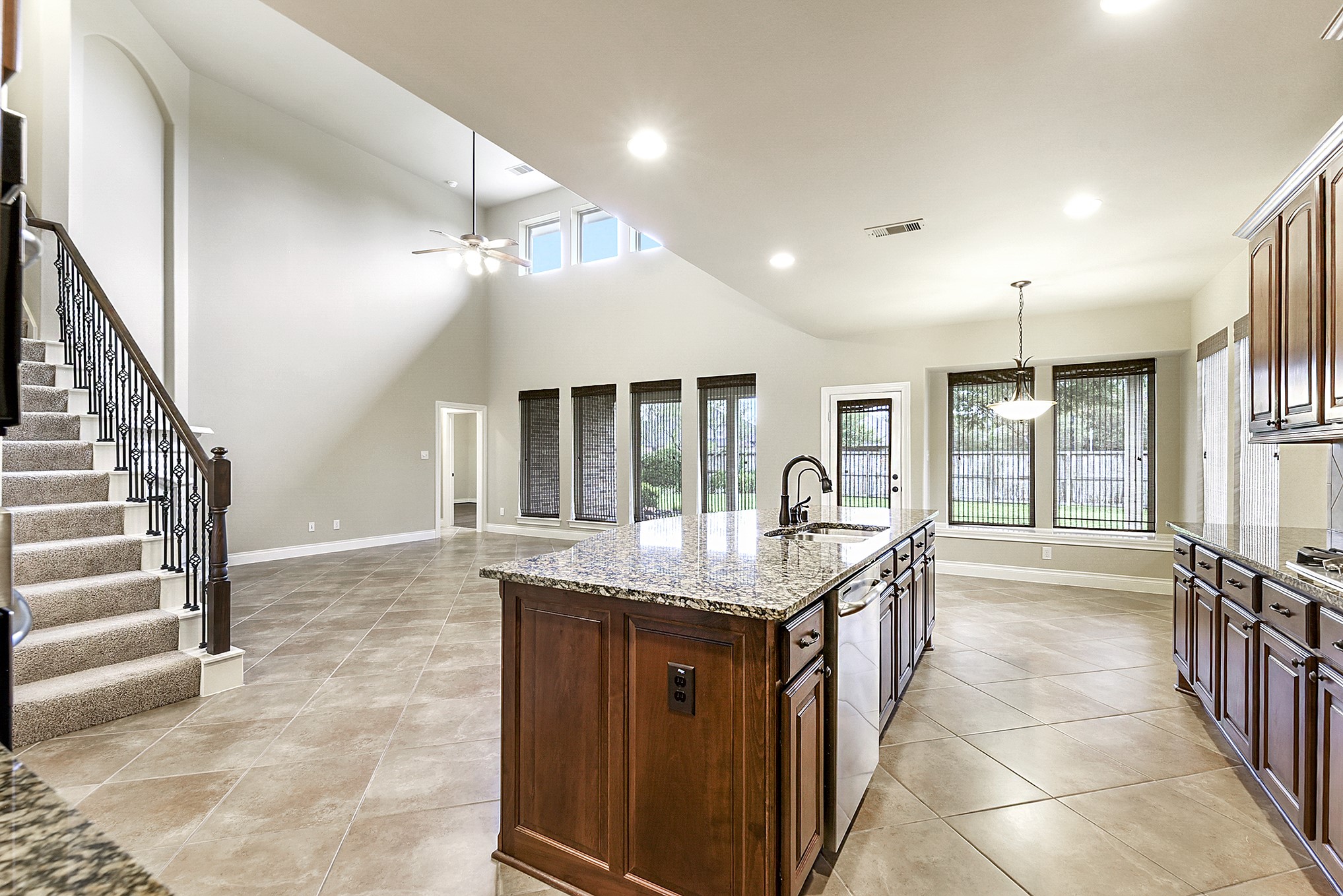 29023 Powder Ridge Drive Katy, TX 77494 - Photo 21 of 50 Experience open-concept living that seamlessly connects the spacious living room, breakfast bar, and formal dining room. Enjoy the lofty ceilings, stunning windows, and drop-down ceiling fan that create a bright and inviting atmosphere. The generous living area easily accommodates a variety of furniture layouts, offering both comfort and flexibility. Tucked into a private corner of the home is the spacious primary en-suite, creating a peaceful retreat with added privacy.