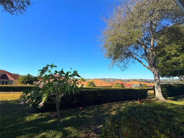 a backyard of a house with table and chairs under an umbrella