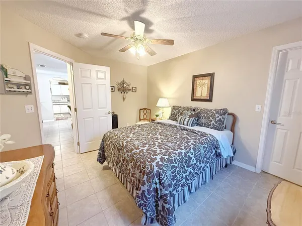 a spacious bedroom with a bed and a chandelier
