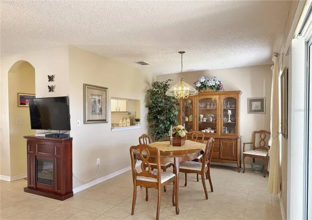 a dining room with furniture a flat screen tv and a chandelier