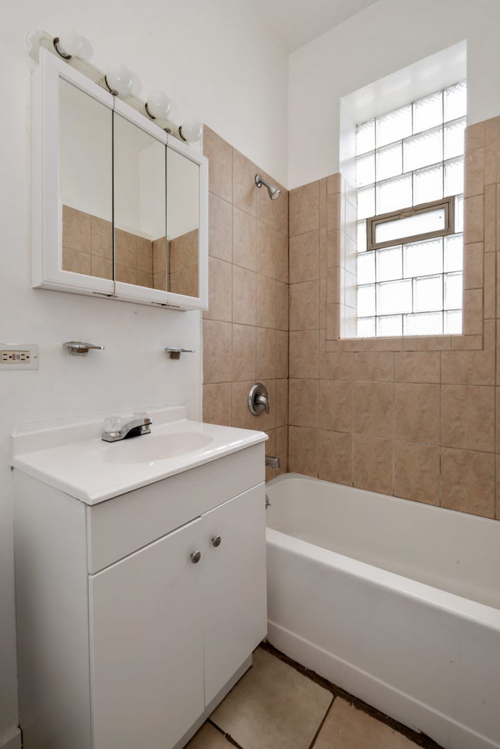 1455 South Avers Avenue Chicago, IL 60623 - Photo 14 of 22 a bathroom with a bathtub a sink a vanity and a window