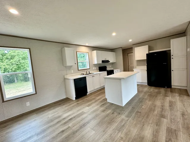 a large kitchen with stainless steel appliances kitchen island a large counter top and a wooden floors