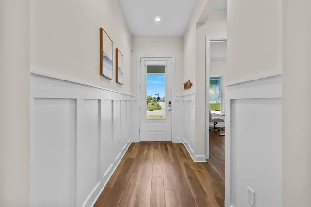a view of a hallway with wooden floor and staircase