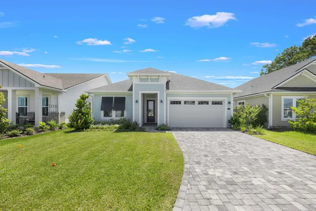 a front view of a house with a garden and yard