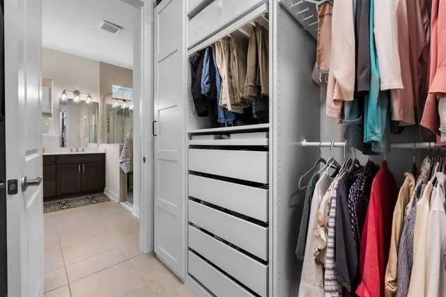 a view of walk in closet with clothes and shoes