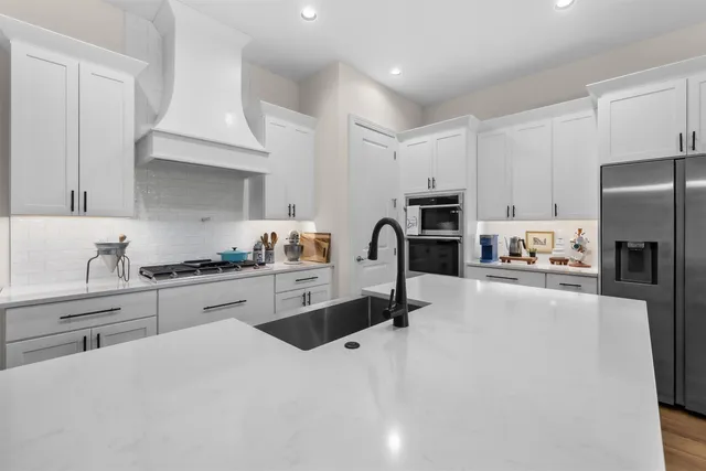a kitchen with granite countertop a refrigerator stove top oven a sink and dishwasher