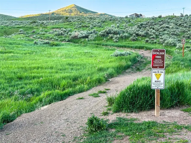 a sign board with a house and yard at the back